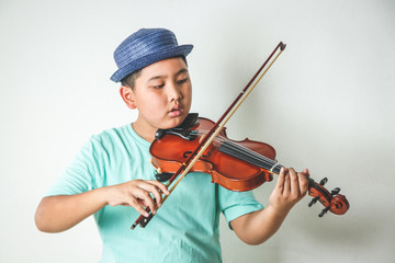 Asian children are playing violin instruments in the classroom.