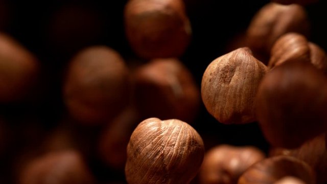 Super slow motion of flying hazelnuts on black background. Filmed on high speed cinema camera, 1000 fps.