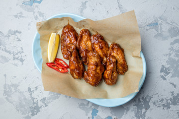 chicken wings in barbecue sauce on grey concrete table