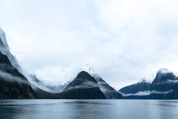 Milford Sound with clouds and snow capped mountains