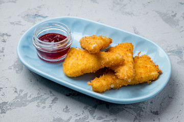 deep fried cheese with berry sauce on grey concrete table