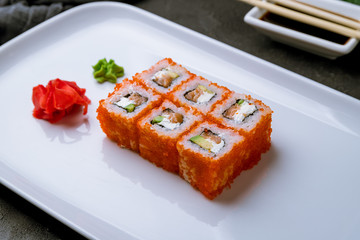 California roll with salmon on black concrete table