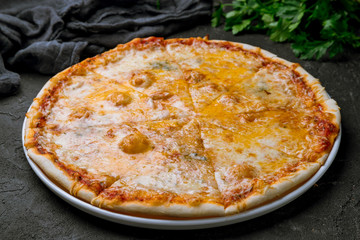 Pizza Quattro formaggi on black concrete table