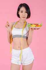 Healthy woman standing holdding vegetable salad diet food in home on pink backgrounds, Healthy concept, Diet concept