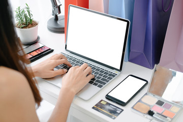 Fototapeta premium Mockup image of Beautiful woman shopping online with laptop and smartphone on online websites, mockup concept