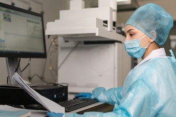Naklejka premium Young female scientist working in the laboratory