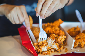 Young women cutting crispy fried chicken wings and crispy chicken legs in restaurants.