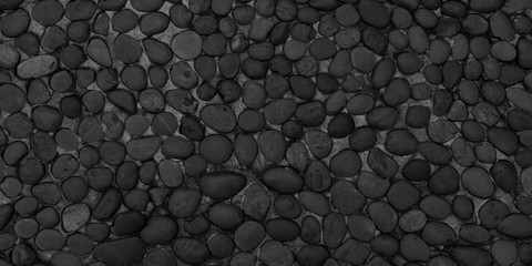 Panorama black pebbles texture background. Panoramic round dark black pebbles or gravel texture surface