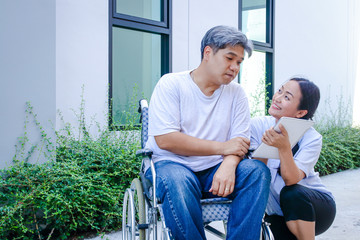 The girl takes care of the male patient sitting on the wheelchair. She wants him to come back strong again.