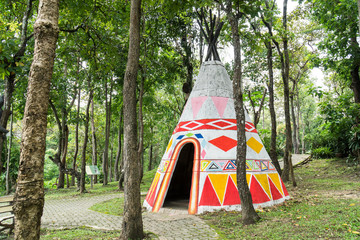 Indian teepee tent in public park with tree plant background. Colorful native american indian tipi...