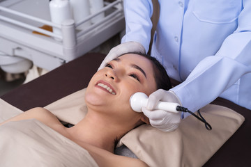 woman receiving ultrasound facial beauty treatment skin care