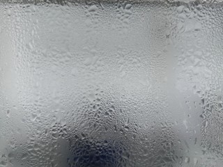 Texture of frozen water drops cool ice glass on background.Closeup.