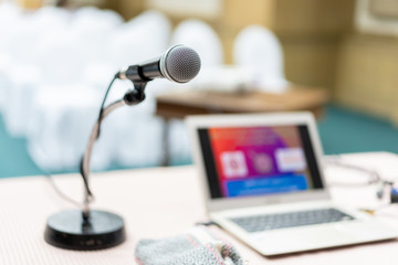 Wired microphone set up on the front of conference room close up with blurred background.  Wired microphone close up with copy space background.