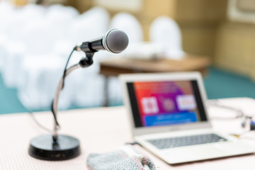 Wired microphone set up on the front of conference room close up with blurred background.  Wired...