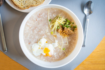 Traditional Thai - Chinese rice soup with pork and boiled egg close up.  Common Asian breakfast meal.