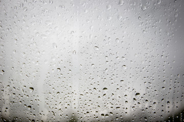 Rain drop on glass with blurred wild background.