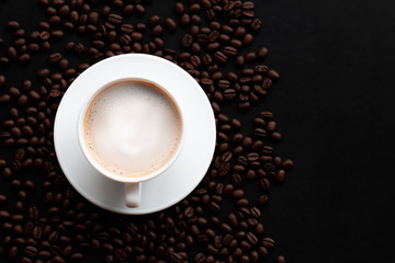 Cappuccino or latte with foaming foam and coffee beans, white coffee cups on the table, top view