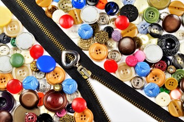 Buttons and zipper, background for the design and creativity of the tailor. Button and zipper fastener on clothes, to connect its parts is fixed in a loop, attached to clothing, shoes, bags. © Николай Зотов