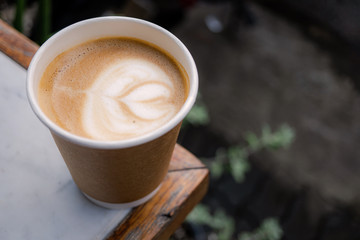 cup of coffee with cream on wooden background , the takeaway paper cup with space to add logo or words