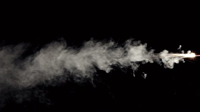 Firecracker burning and bursting smoke with sparks from side on black background