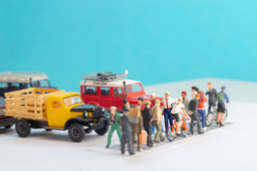 Miniature toys of a business man with a red tie and holding his jacket crossing a road - done for the day or a hot day concept.