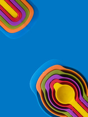 Measuring spoon set made of colorful plastic on a blue background, kitchen equipment. Group of...