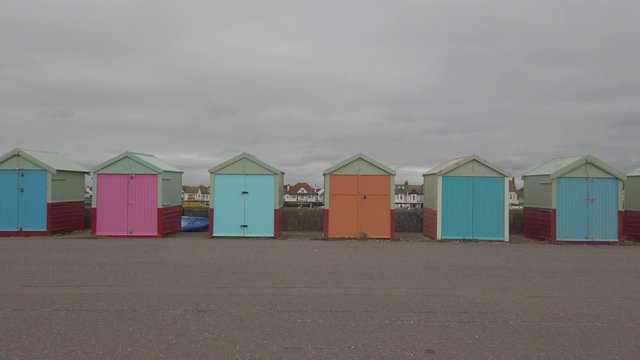 Wide shot of colourful beach huts in Brighton, England.