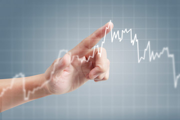 Hand touching graphs of financial indicator and accounting market economy analysis chart
