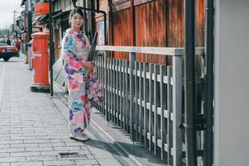 Fototapeta na wymiar Japanese Woman in Kimono walking on a street of Gion in Kyoto Japan.