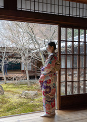 Fototapeta na wymiar Women Floral Printed Long Kimono in Gion House is an old wooden, traditional style at Gion Shijo Kyoto Japan. 