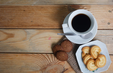 Coffee cup and cookie on wood