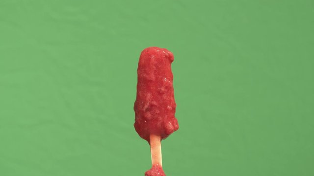 Time lapse closeup of an ice pop melting. Filmed with a green screen for background removal and compositing.