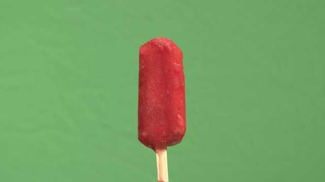 Time lapse closeup of an ice pop melting in reverse. Filmed with a green screen background for removal and compositing.