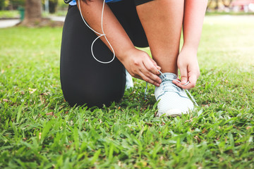 Fat girl exercising in the garden Sit to tie shoes to run.