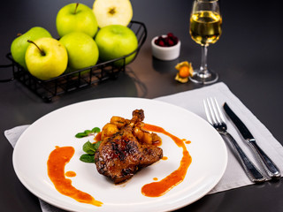 Confit duck with apple sauce. Restaurant serving dishes.
