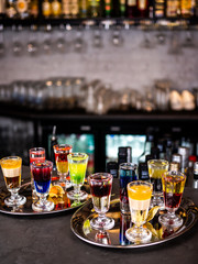 Multi-colored alcoholic cocktails. Set of shots with cocktails. Colored drinks in glasses.