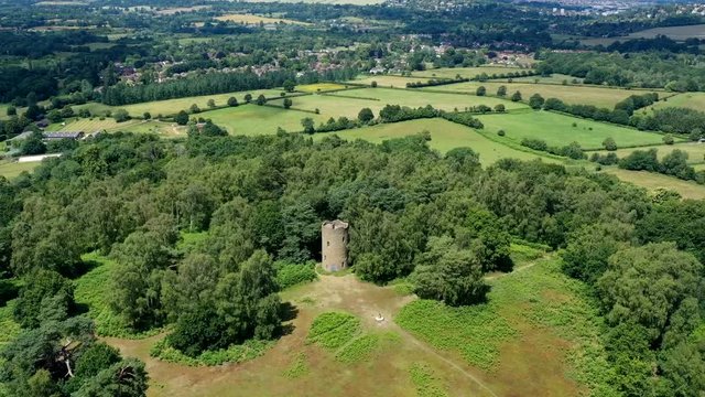 Aerial hyper lapse moving round a folly on top of a hill in the English countryside.