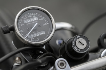 Close up picture of the vintage style of dark speedometer gauge and old on-off ignition switch from...