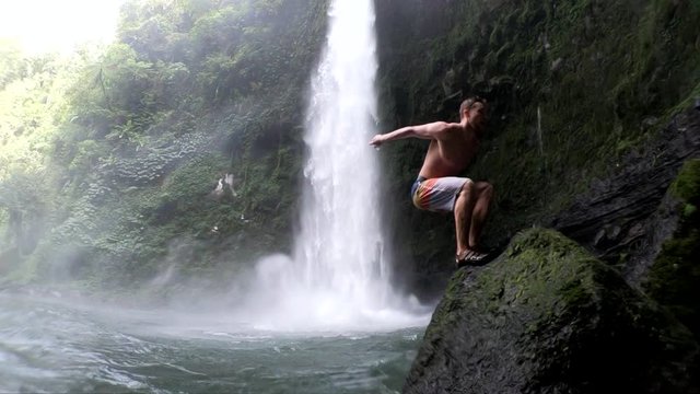Slow Motion Shot (240fps) of a man doing a backflip into the water at NungNung Waterfall in Bali, Indonesia.