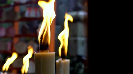 Slow Motion of candles burning in small temple at famous grounds of Fushimi Inari Taisha shrine in Kyoto. The candle flame that people raised for worship in Japan sanctuary.-Dan - Powered by Adobe