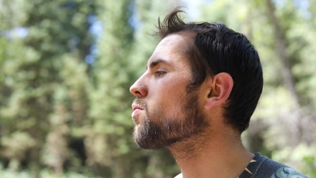 Slow Motion Shot of a man popping a cherry in his mouth and chewing on it.