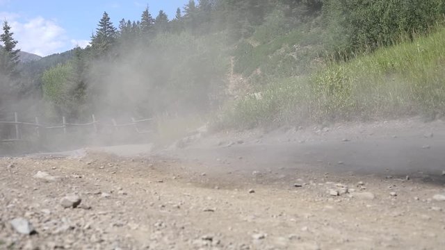 Shot of an ATV Rider driving his quad really fast around a corner, leaving a large dirt cloud behind him.