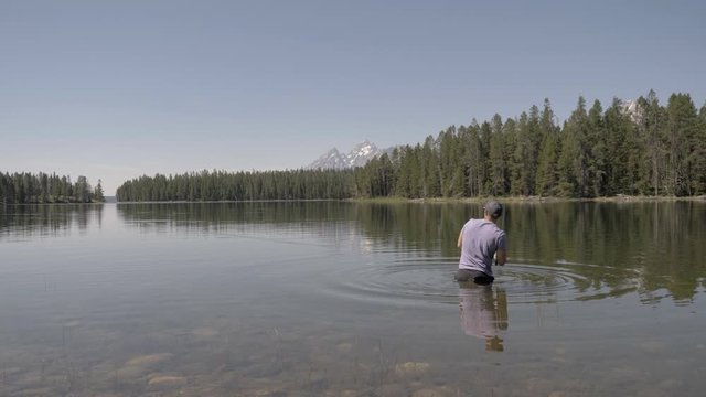 Man fishing on lake in the Gand Tetons National park 4k