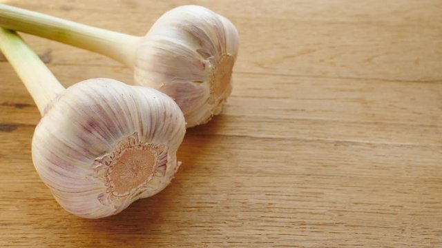 Two garlic bulbs on wooden rustic board. Healthy food. Place for text, copy space