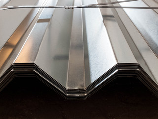Fototapeta premium Stacked stainless galvanized profiled sheet. Silver colored construction material