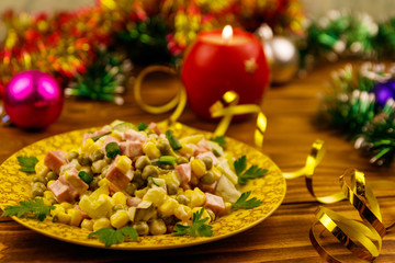 Tasty festive salad, Christmas decor and candle on wooden table