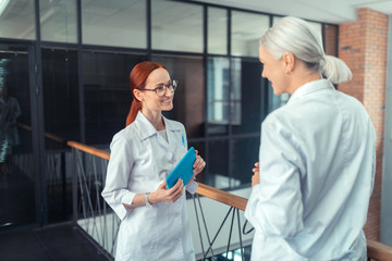 Obraz premium Smiling young female doctor standing in the corridor
