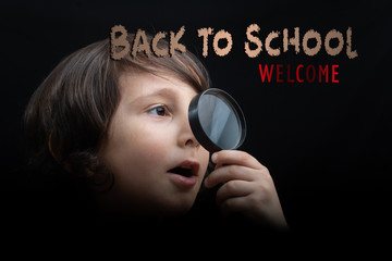 Portrat of a young boy looking through the magnifying glass