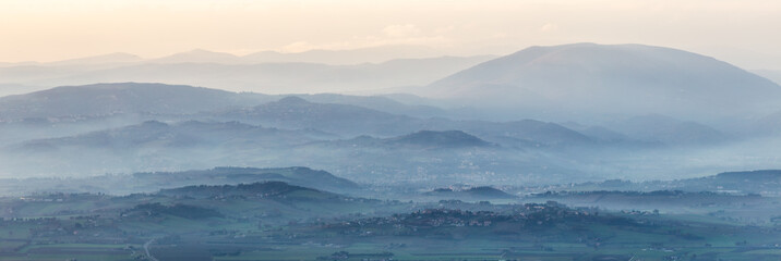 A panoramic view of Umbria valley with hills and mist