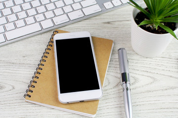 Office desk white wooden table with computer,keyboard,smart phone,pen,notebook